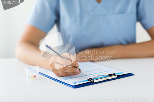 Image of doctor with medicines and clipboard at hospital