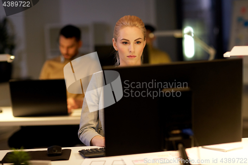 Image of businesswoman at computer working at night office