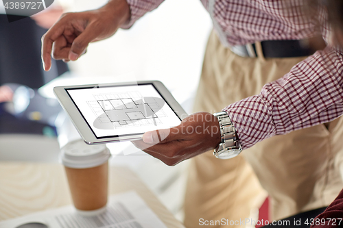 Image of architector with blueprint on tablet pc at office