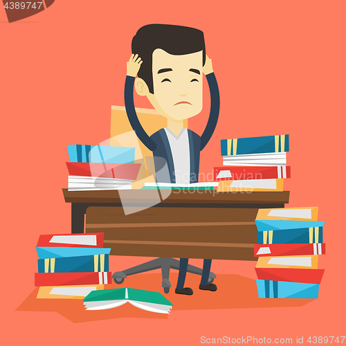 Image of Student sitting at the table with piles of books.