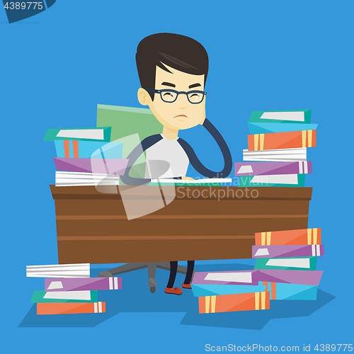 Image of Student sitting at the table with piles of books.