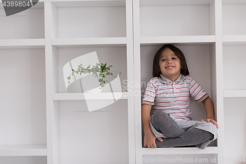 Image of young boy posing on a shelf