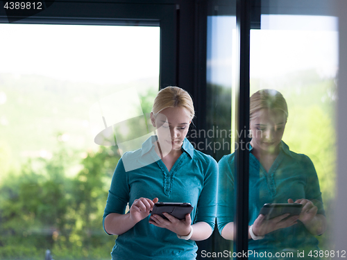 Image of young women using tablet computer by the window