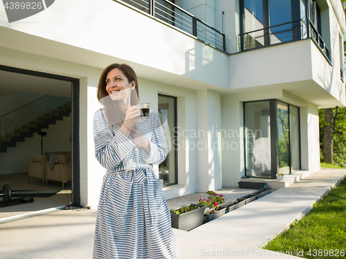 Image of woman in a bathrobe enjoying morning coffee