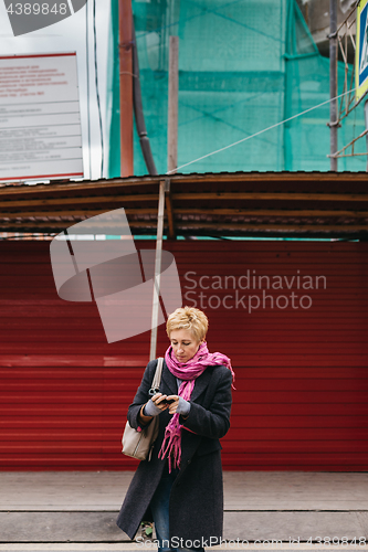 Image of Woman with phone on city street