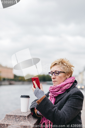 Image of Woman with phone on esplanade