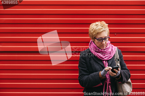 Image of Adult woman with smartphone on street