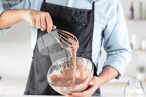 Image of A cook with eggs on a rustic kitchen against the background of men\'s hands