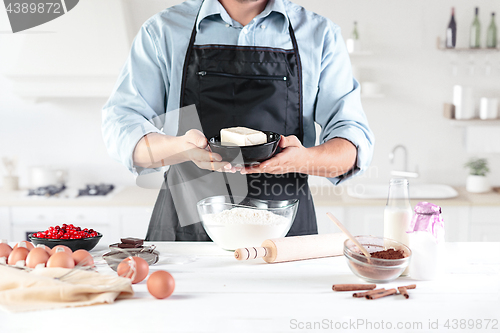 Image of A cook with eggs on a rustic kitchen against the background of men\'s hands