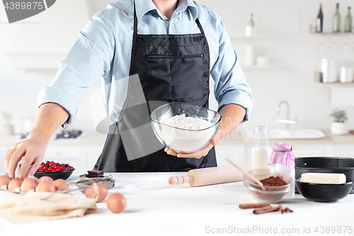 Image of A cook with eggs on a rustic kitchen against the background of men\'s hands