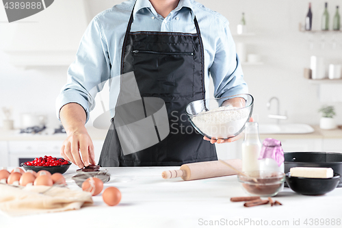 Image of A cook with eggs on a rustic kitchen against the background of men\'s hands