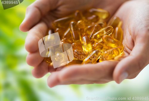 Image of hands holding cod liver oil capsules