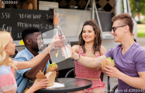 Image of friends clinking drinks and eating at food truck