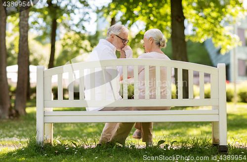 Image of happy senior couple sitting on bench at park