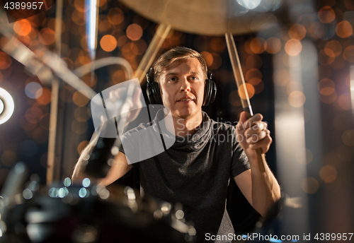 Image of male musician playing drum kit at concert