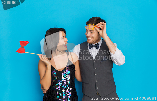 Image of happy couple with party props having fun