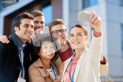 Image of business team with conference badges taking selfie