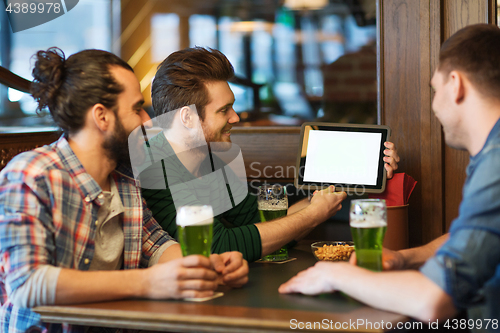 Image of friends with tablet pc and green beer at pub