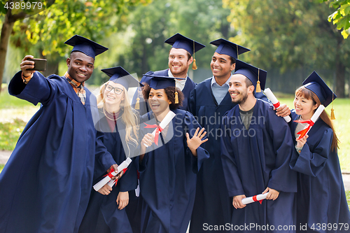 Image of students or graduates with diplomas taking selfie
