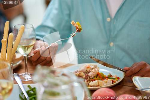 Image of close up of man eating with fork and knife