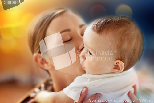 Image of close up of happy young mother kissing little baby