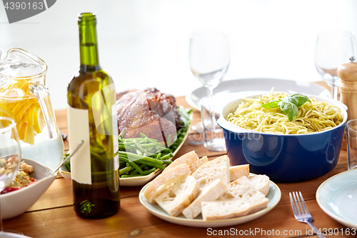 Image of bottle of wine and food on served wooden table