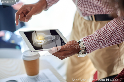 Image of businessman with lightbulb on tablet pc at office