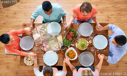 Image of group of people at table praying before meal