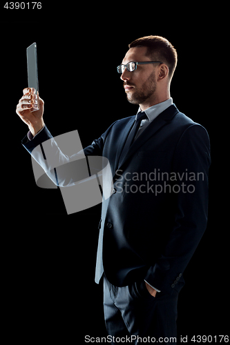 Image of businessman in suit working with transparent tablet pc