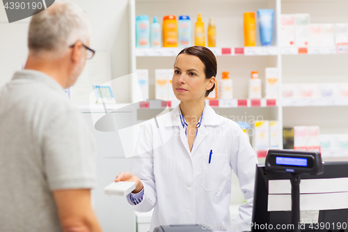 Image of apothecary showing drug to senior man at pharmacy