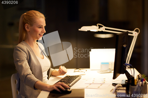 Image of businesswoman at computer working at night office