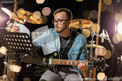 Image of man playing guitar at studio rehearsal