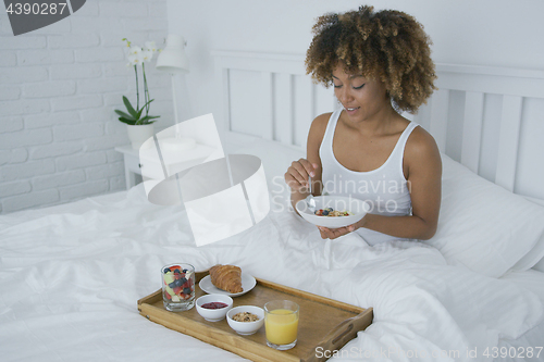 Image of Content woman having breakfast in bed