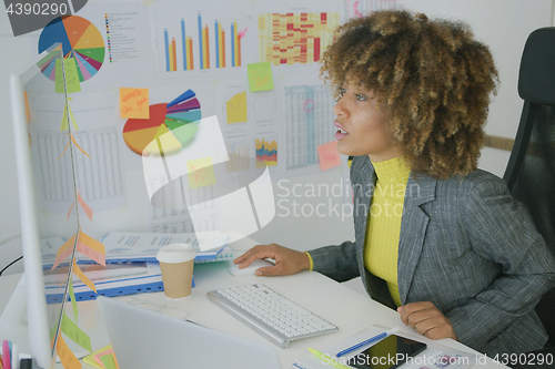 Image of Concentrated woman watching computer in office