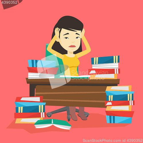 Image of Student sitting at the table with piles of books.