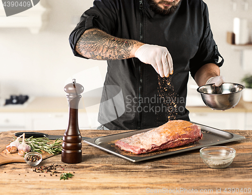 Image of Man cooking meat steak on kitchen