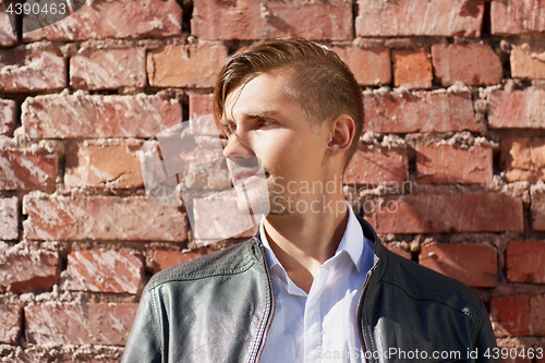 Image of portrait of man in leather jacket over brick wall