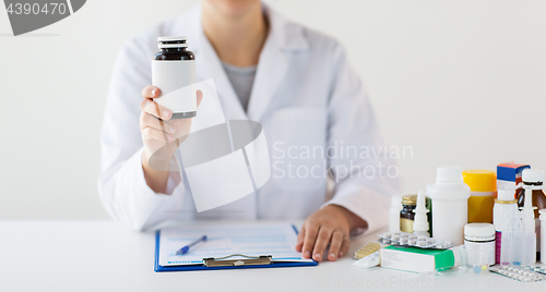 Image of close up of doctor with medicines and clipboard