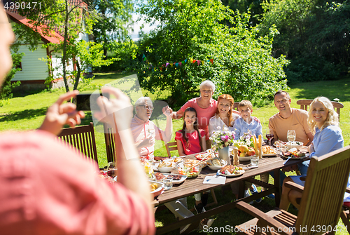 Image of happy family photographing by smartphone in summer
