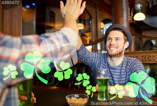 Image of friends with green beer making high five at pub