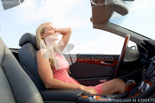 Image of happy young woman in convertible car