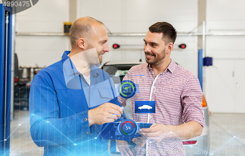 Image of auto mechanic with clipboard and man at car shop