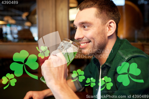 Image of close up of man drinking green beer at bar or pub