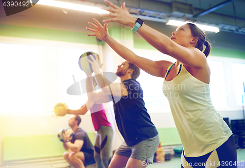 Image of group of people with medicine ball training in gym