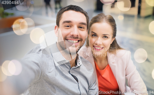 Image of happy couple taking selfie in mall or office