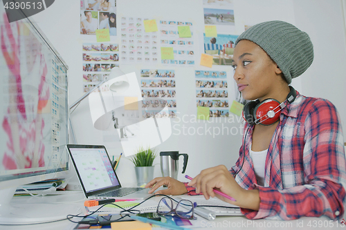 Image of Stylish young woman working in office