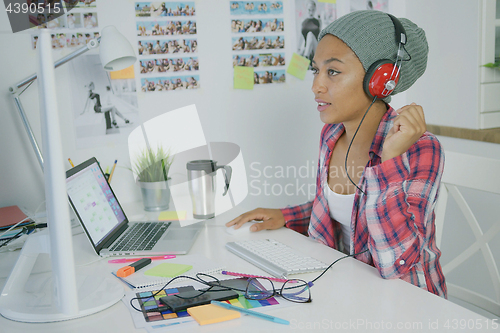 Image of Trendy worker in headphones working