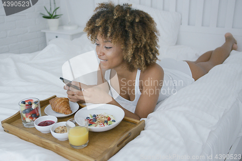 Image of Pretty model having meal in bed