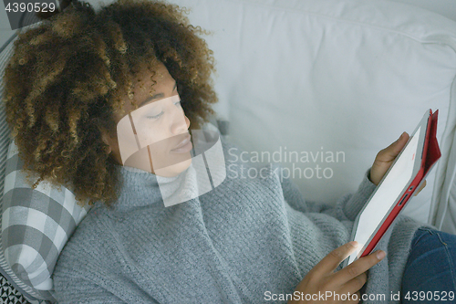 Image of Woman chilling with tablet at home