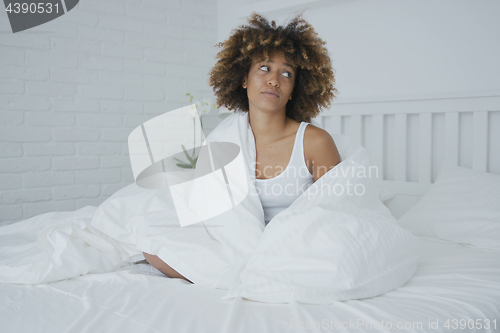 Image of Upset woman cuddling in bed